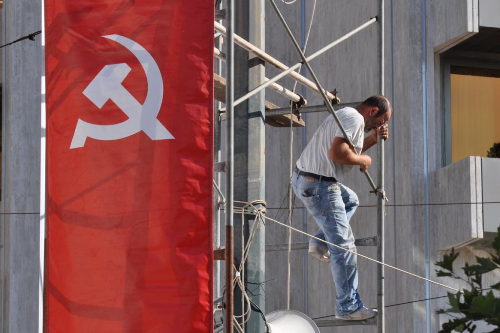 A worker climbs on scaffolding as he prepares the venue for the Greek Communist Party party election rally in Athens, Greece, September 16, 2015. The outcome of Sunday's Greek national election looks more uncertain than ever after the country's two dominant politicians ruled out working with each other and apparently failed to sway undecided voters in a final televised debate. REUTERS/Michalis Karagiannis