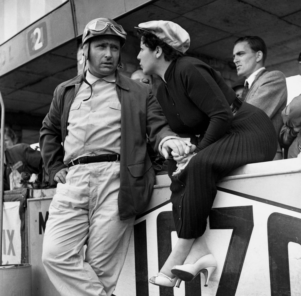 1954, Silverstone, Northamptonshire, England, UK --- Argentine Juan Manuel Fangio, the five-time world motor racing champion, talks to his wife at the Silverstone racing circuit in Northamptonshire, where is participating in the Cuban Grand Prix. England, 1954. --- Image by © Hulton-Deutsch Collection/CORBIS