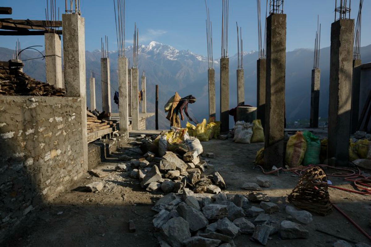 The village of Barpak, in Gorkha district, close to the epicenter of the earthquake, which destroyed almost the entire village. Villagers rebuilding houses and pathways and building a new religious stupa. Much of the work is accomplished communally. Buddha Himal mountain in background. by James Nachtwey