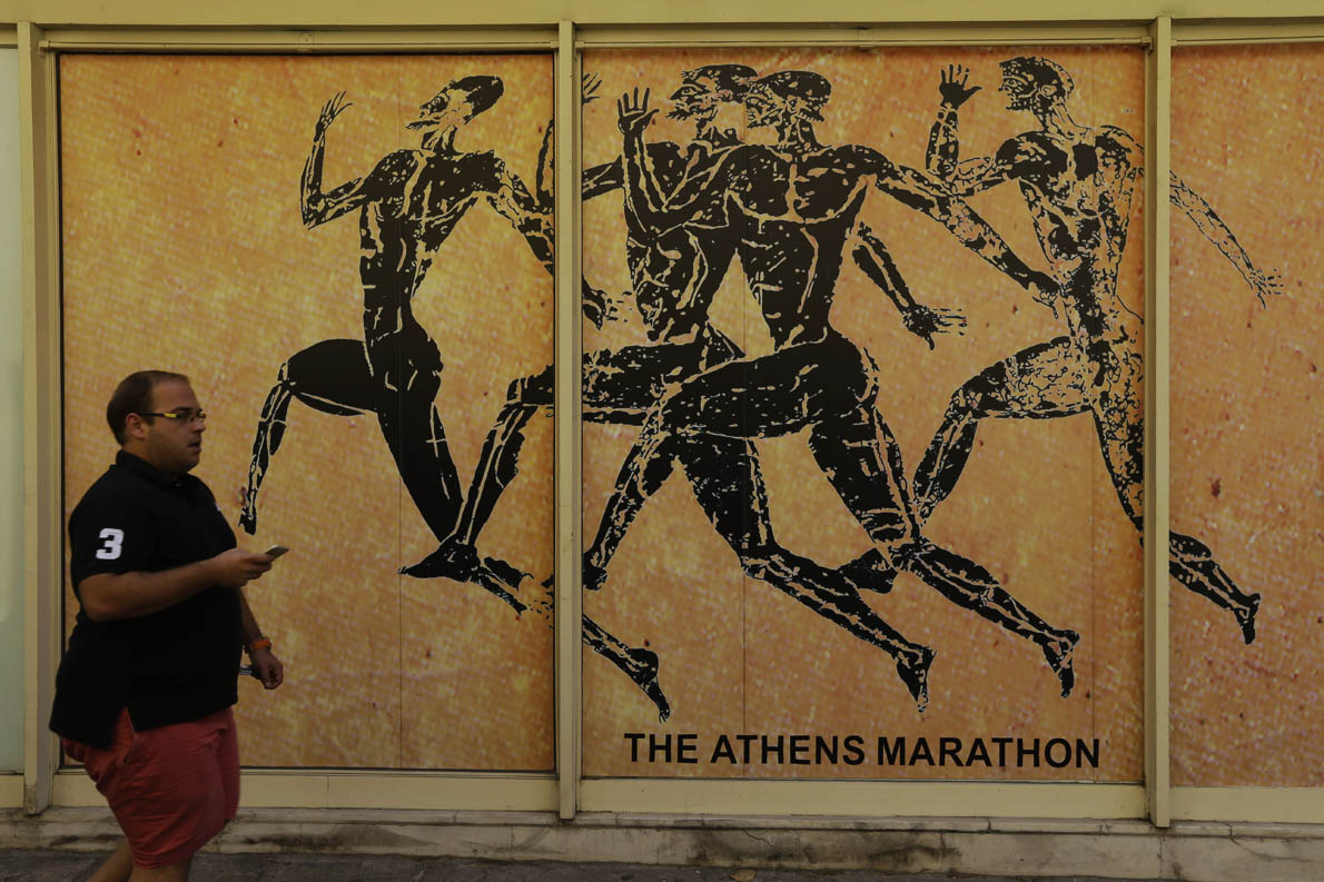 A man passes a store front of souvenir shop in the Plaka tourist district of Athens, Tuesday, July 28, 2015. Emissaries from Greece's international creditors are holding preparatory talks with Greek officials as the aim is to thrash out the terms of the deal before Aug. 20, when Greece must make a debt payment that it cannot afford without new loans. (AP Photo/Thanassis Stavrakis)