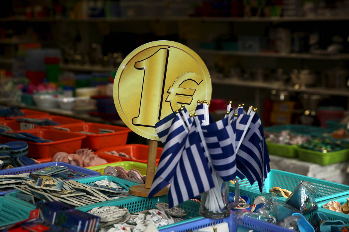 Greek flags are displayed for sale for one Euro at a shop in central in Athens, Greece July 26, 2015.Greek banks are set to keep broad cash controls in place for months, until fresh money arrives from Europe and with it a sweeping restructuring, officials believe. REUTERS/Yiannis Kourtoglou